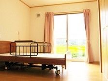 床がフローリングで、介護用ベッドが完備されている個室である。窓からは外の景色がよく見え、明るい陽射しが入る。