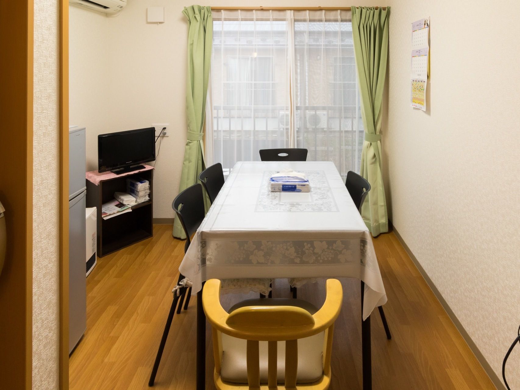 談話室には、部屋の中央に白いクロスを掛けたテーブルと椅子が配置されている。壁際には、コンパクトなテレビや小型の冷蔵庫が置いてある。
