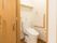 清潔感のあるトイレで、壁にはつかまりながら立座りできるL字型の手すりが設置されている。出入口も広く段差もない。