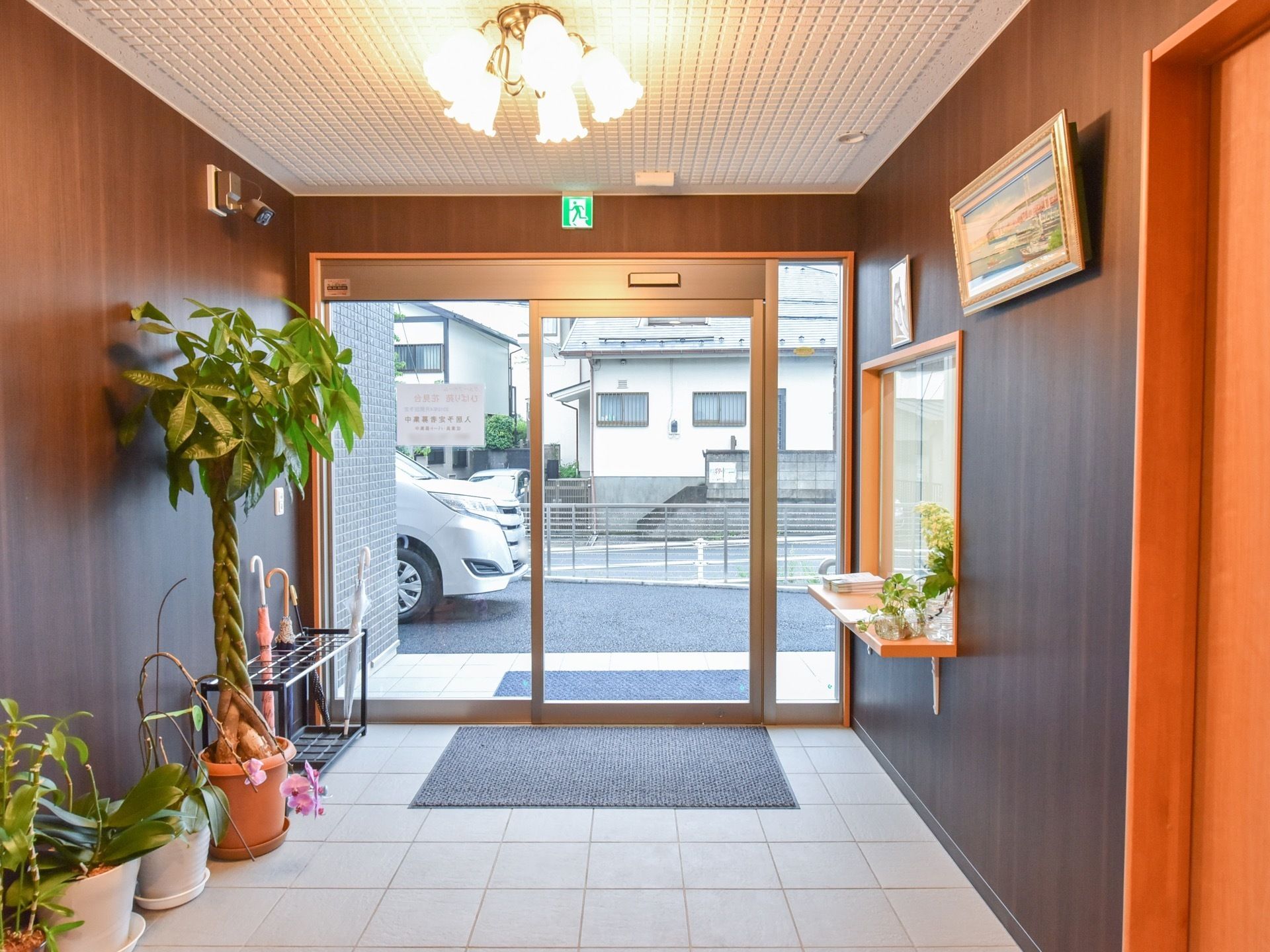 自動ドアが設置されている。ドアの外と室内側の両方にマットが敷かれている。傘立てが用意されている。防犯カメラが付いている。