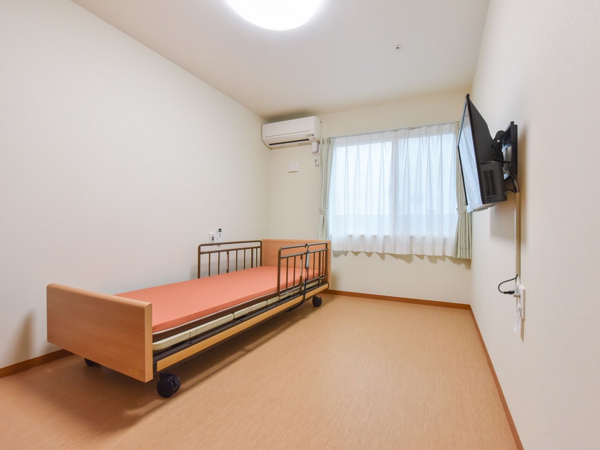 日当たりがよい部屋にはベッドが置かれており、柵が付いているので安心して就寝できる。テレビも完備されているので自宅のように過ごせる。
