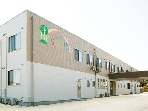 １階と２階のデザインが違い、壁にカラフルなイラストが描かれている横長な施設建物