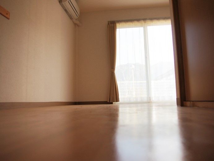 窓からやさしい陽射しが入る居室は木目調を基調としており、温かみある空間である。居心地よくおだやかにお過ごしいただける。