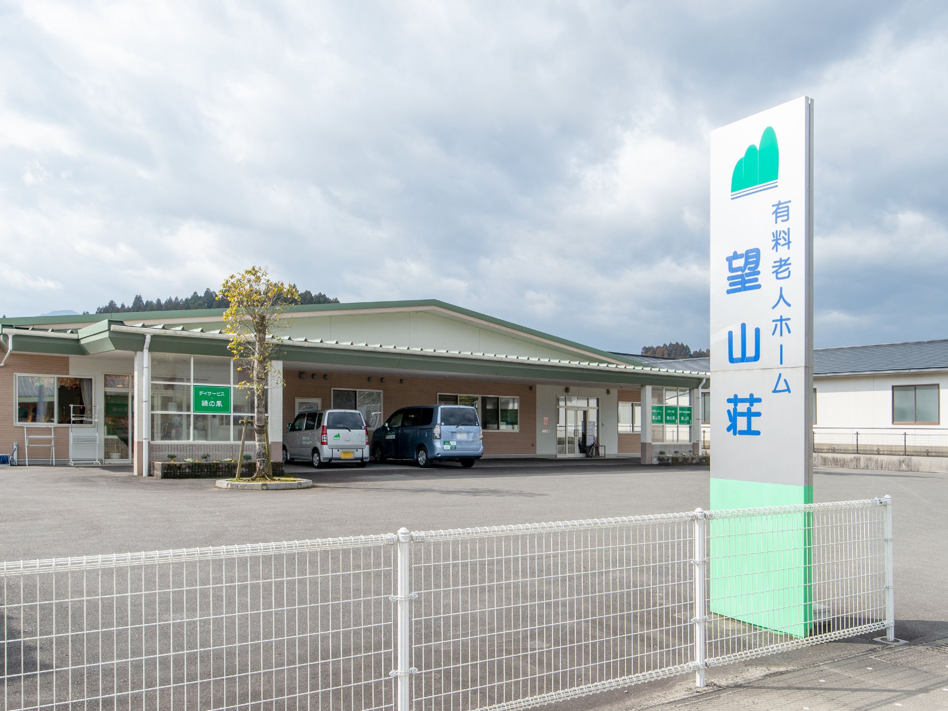 のどかな環境に立地している平屋建ての施設である。敷地入口には、大きな青色の文字で施設名称が表示された看板が立っている。