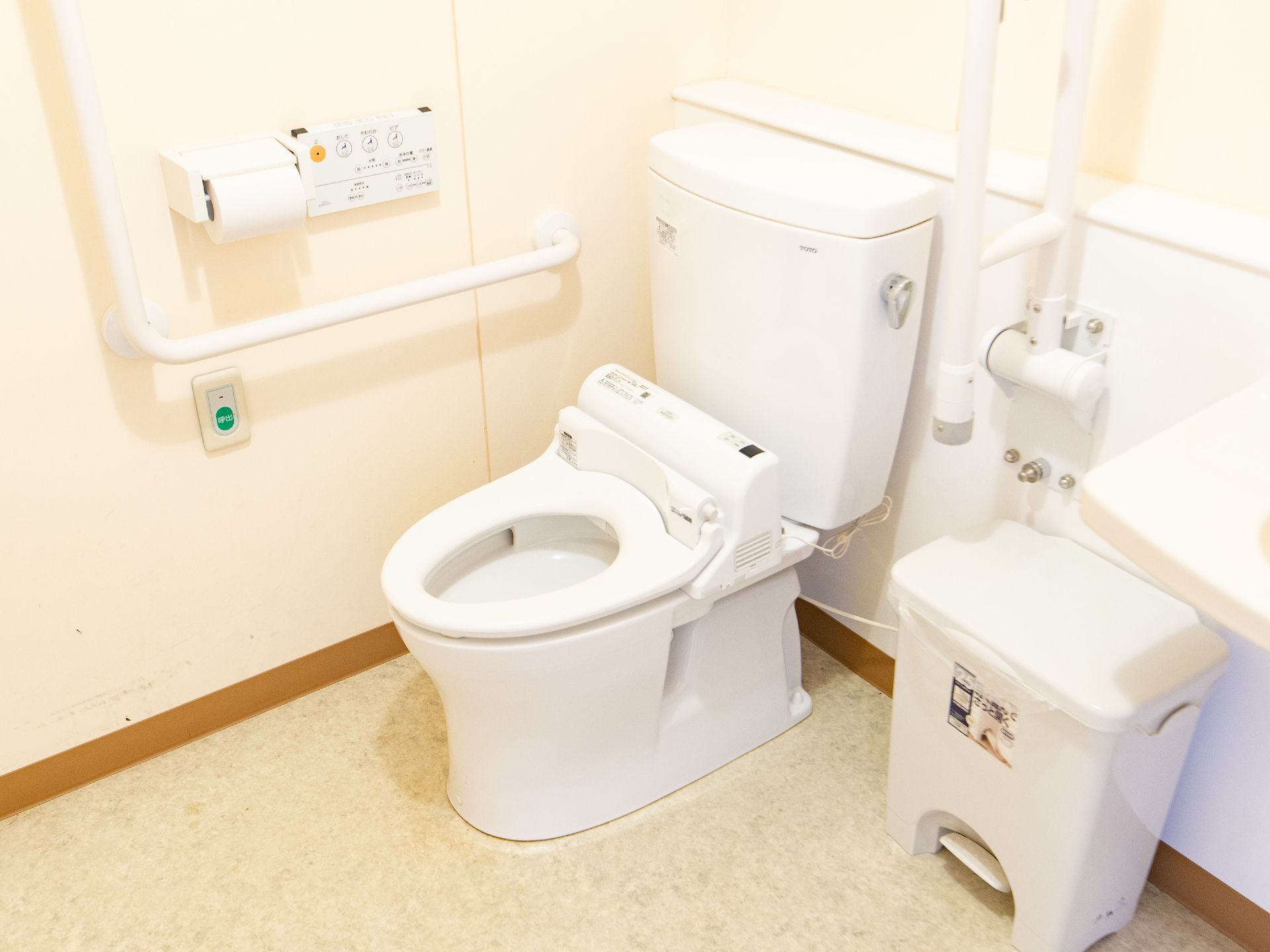 トイレは暖房洗浄機能つきの便座になっている。トイレットペーパーホルダーの下に、ナースコールボタンがついている。