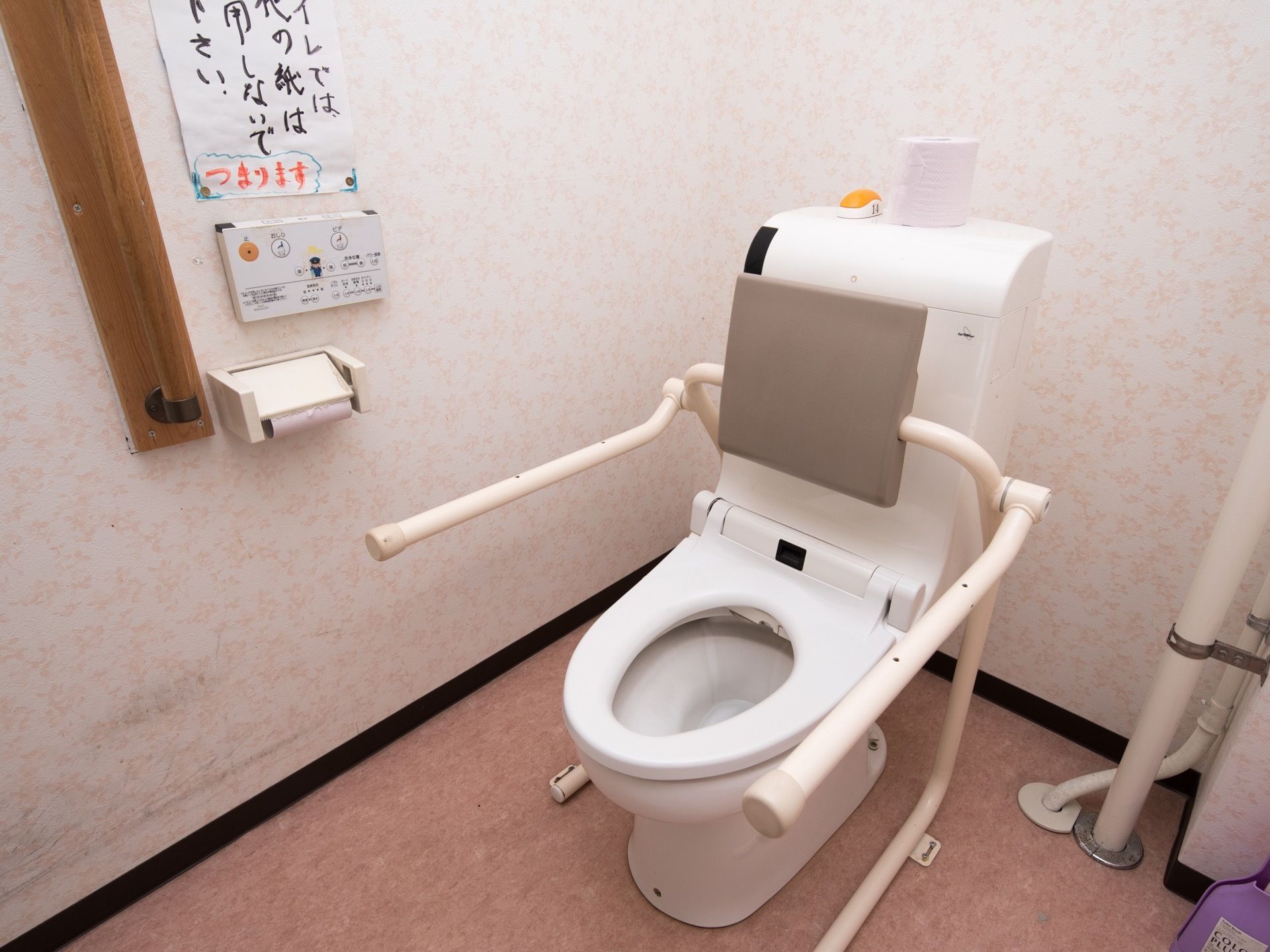 トイレには洋式便器が設置されており、便器横には可動式の手すりがある。トイレタンクの上には予備のトイレットペーパーが置かれている。