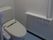トイレには温水洗浄便座が設置され、周囲には手すりが設けられている。壁の色は白色系で明るい雰囲気である。