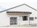 壁の色は白色系で平屋建ての建物である。屋根が設置された玄関にはスロープが設けられており、安全に通行できる。
