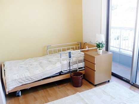 居室の窓際には電動のリクライニング式ベッドが設置されており、入居者様は楽に起き上がることができ便利である。