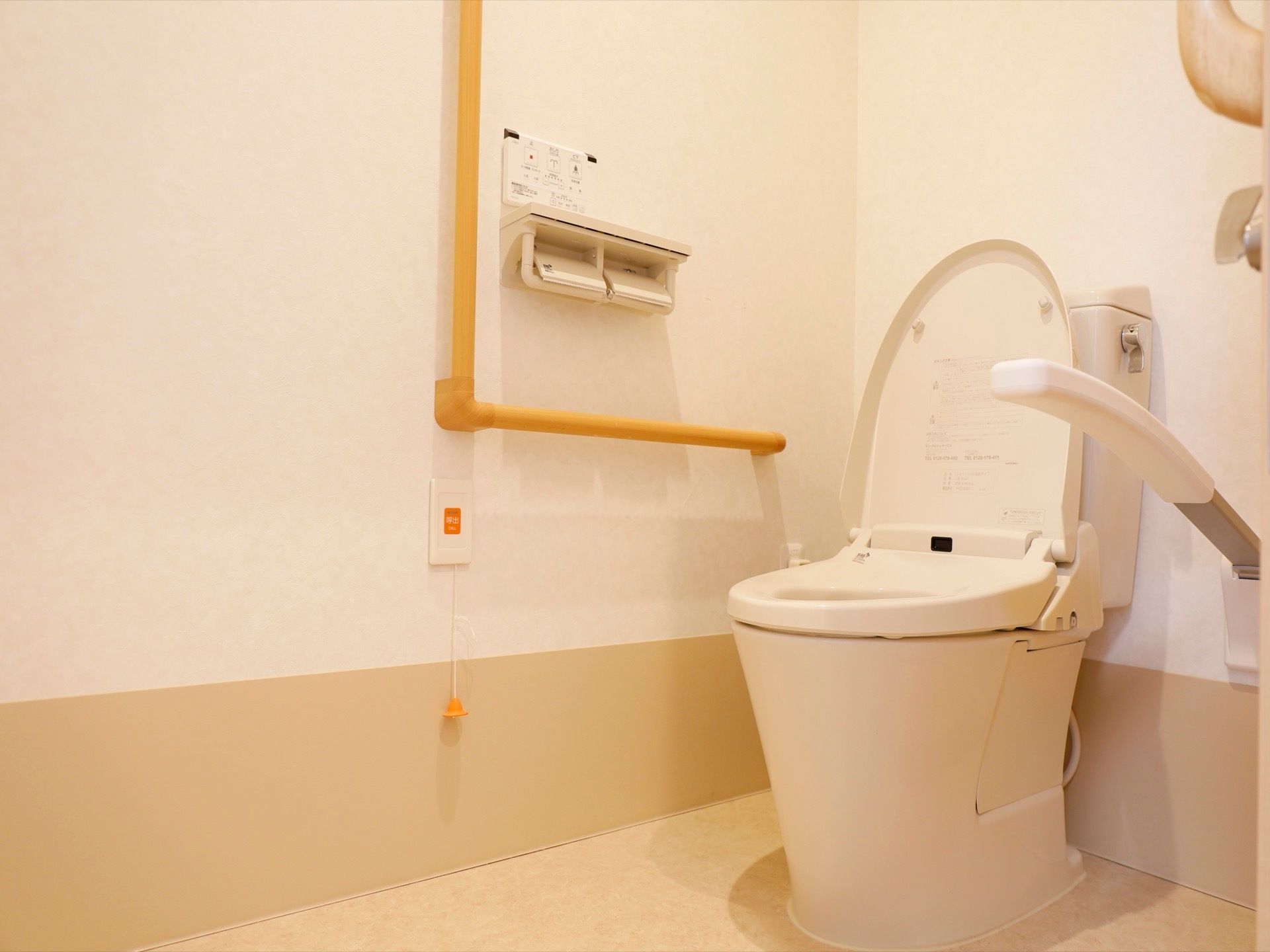 温水洗浄便座式のトイレがある。壁には手すりが備えられている。紐を引っ張るタイプの呼び出しベルがある。