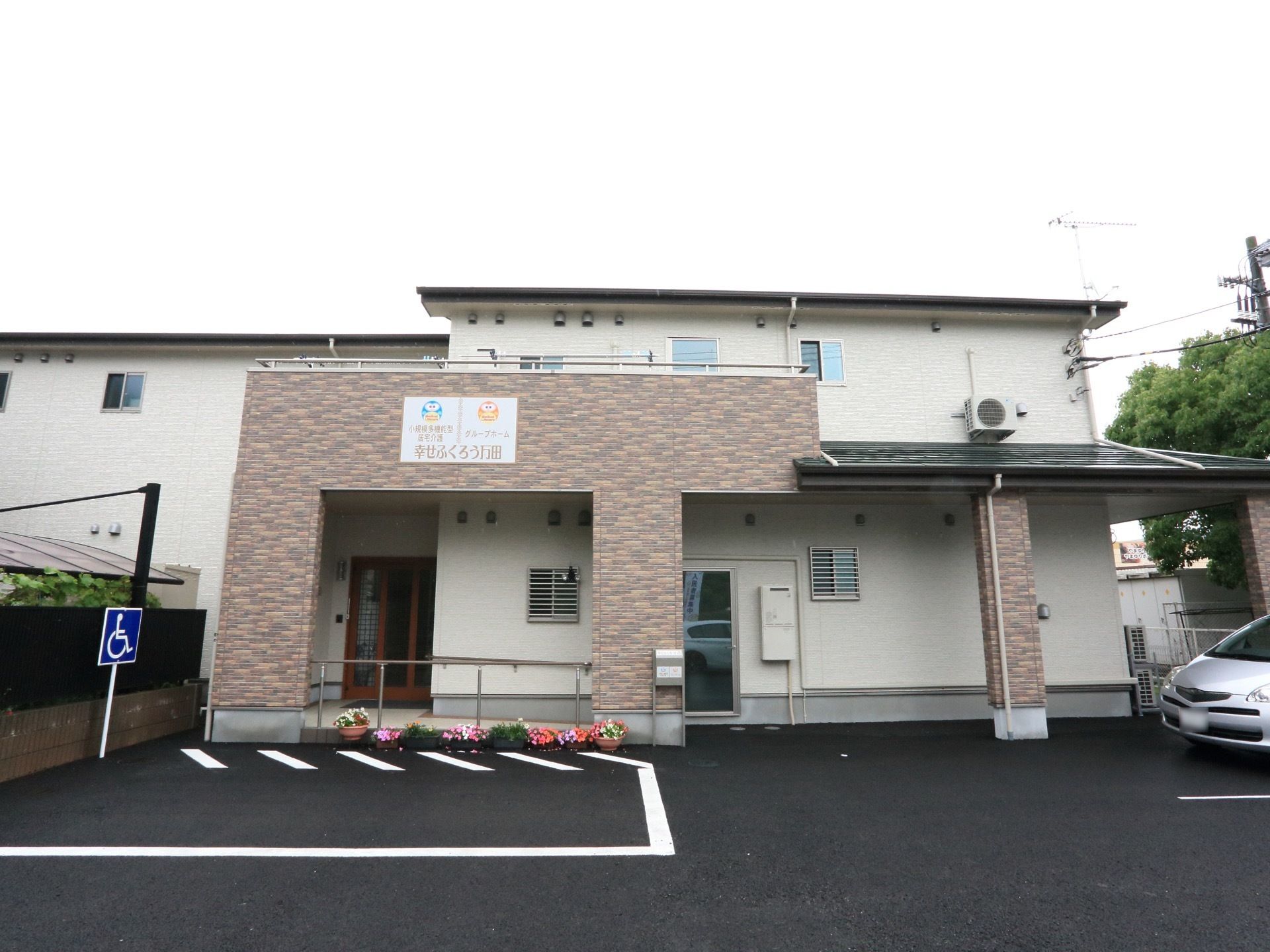 レンガ調の外壁がアクセントになった施設である。建物の前には、身障者専用の広々した駐車場も設けられている。