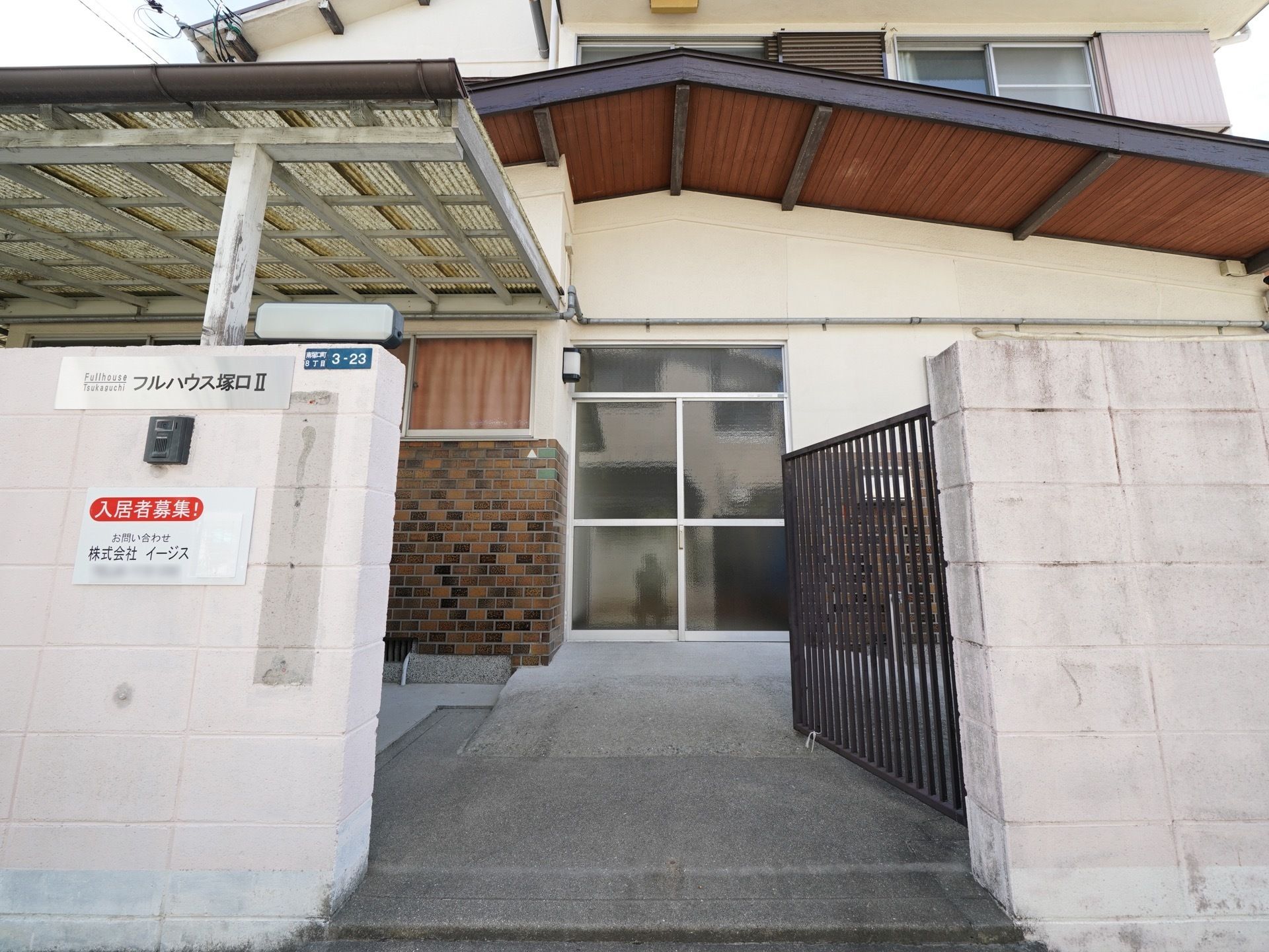 施設はベージュ色が基調の外壁になっている２階建ての建物である。玄関前のスペースに屋根が設置されており、雨の日も安心である。