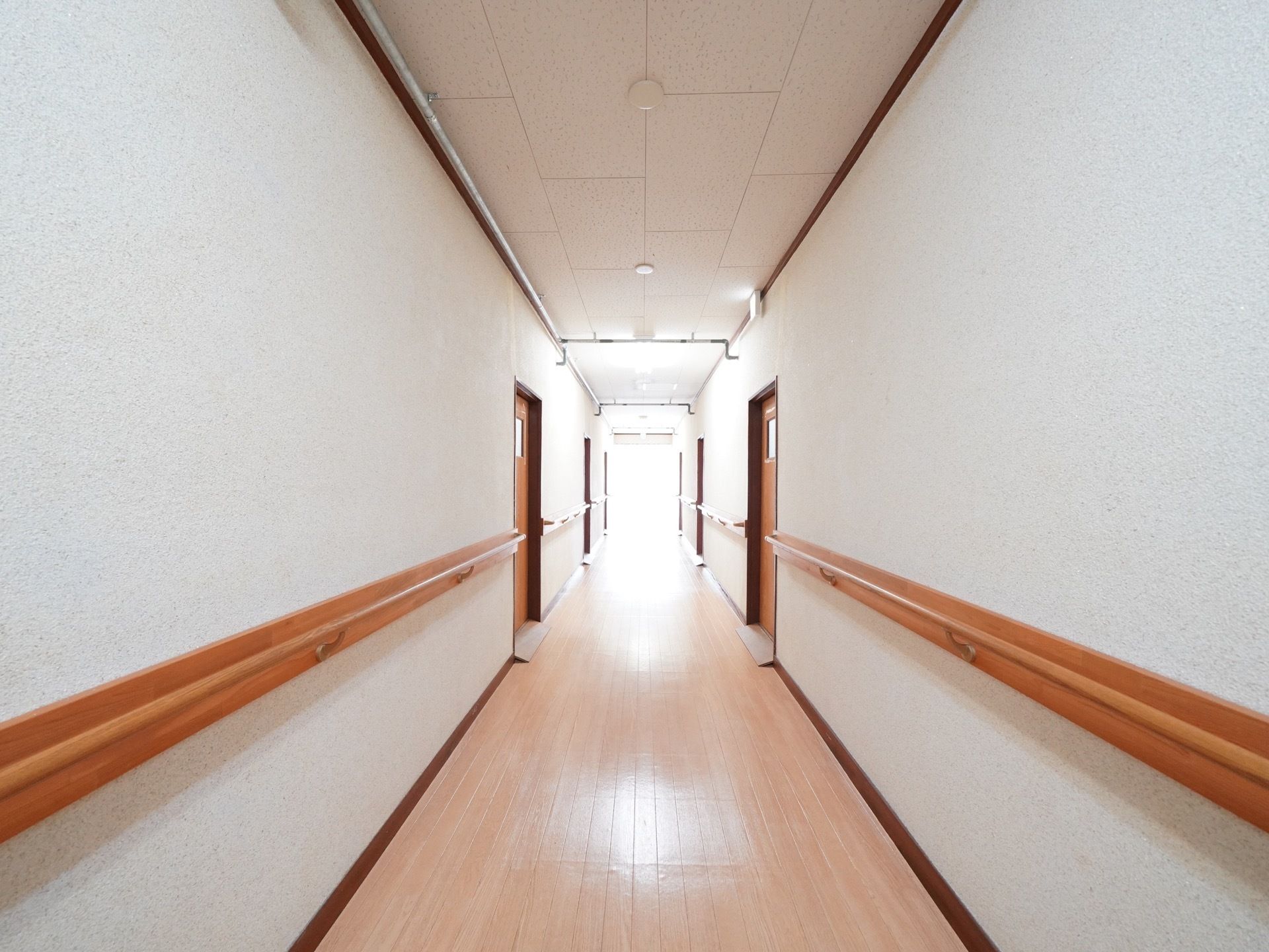 廊下は広い幅を確保している。窓があり、外からの光が入る明るいスペースになっている。白い壁で清潔感がある。