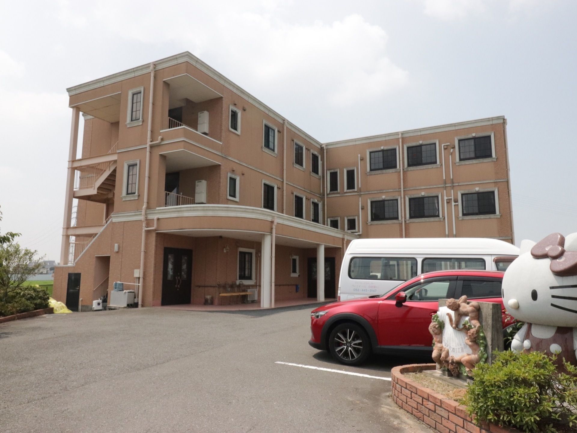 建物本体の全体像。３階建て構造になっており、全体的な見た目が茶色い外壁をした特徴的なデザインとなっている。