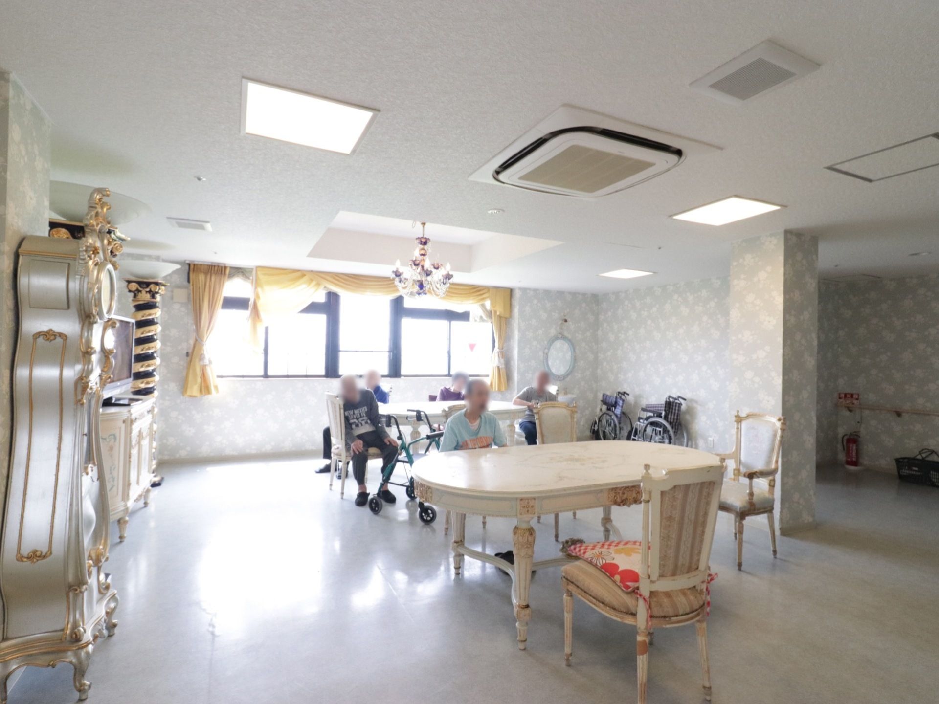 入居者様が共有スペースを使用している様子。座席や家具などは凝ったデザインの白い調度品で統一されている。