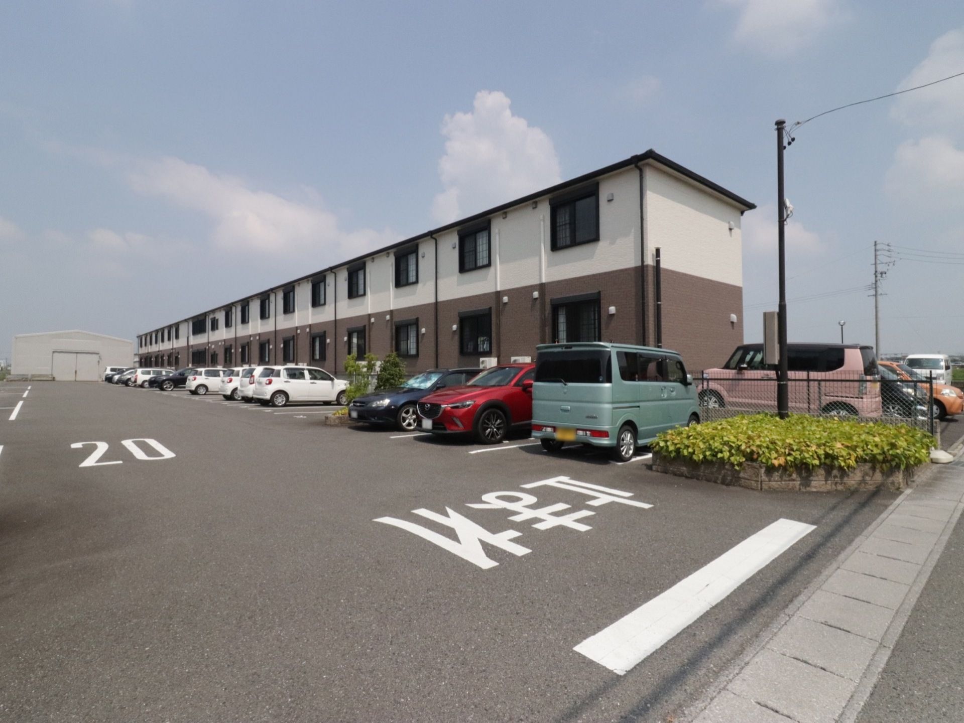 ２階建てのアパート風の建物である。１階は赤く、２階は白いレンガ調の外壁である。広々とした駐車場が完備されている。