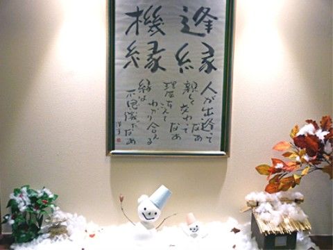 季節にちなんだ装飾が飾られている。文字の書かれた額の前に、降り積もった雪が表現され、雪だるまの人形が２体と、植物が置かれている。