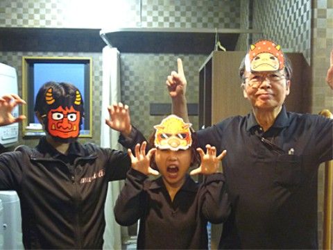 節分の日にちなんだイベントの様子である。男性の入居者様のほかスタッフも鬼の面を着け、カメラに向かってポーズをとっている。