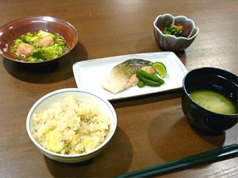 季節にちなんだ食事で、茶碗には栗ご飯がよそわれており、副菜は魚など２品で、小鉢の漬物と味噌汁に箸が置かれている。