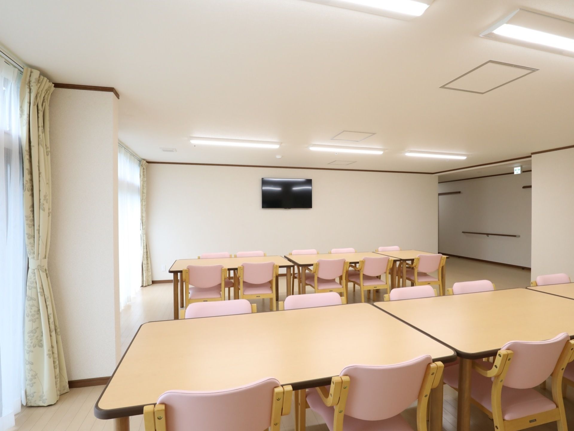 白い壁で清潔感のある広いスペースである。テーブルとひじ掛けのついた椅子を設置しており安全に座ることができる。