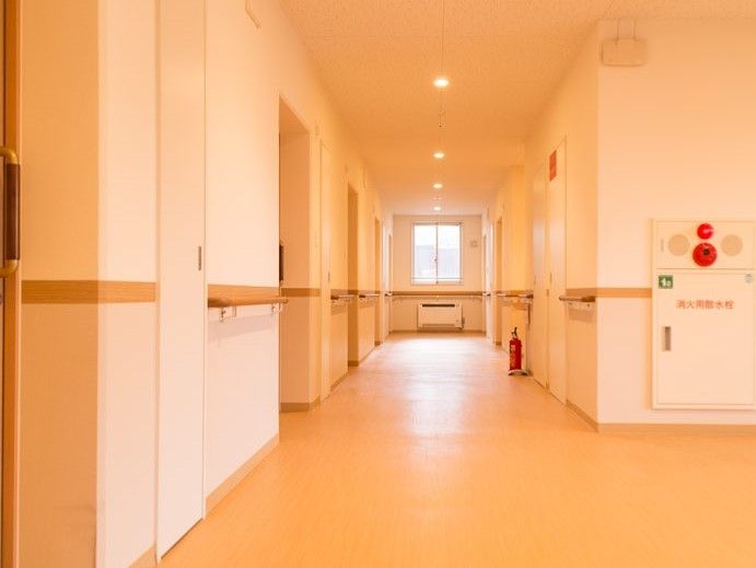 広く段差のない廊下。手すりも各所に設置してある。ご入居様の安全のために、非常ベルも設置し万全を期している。