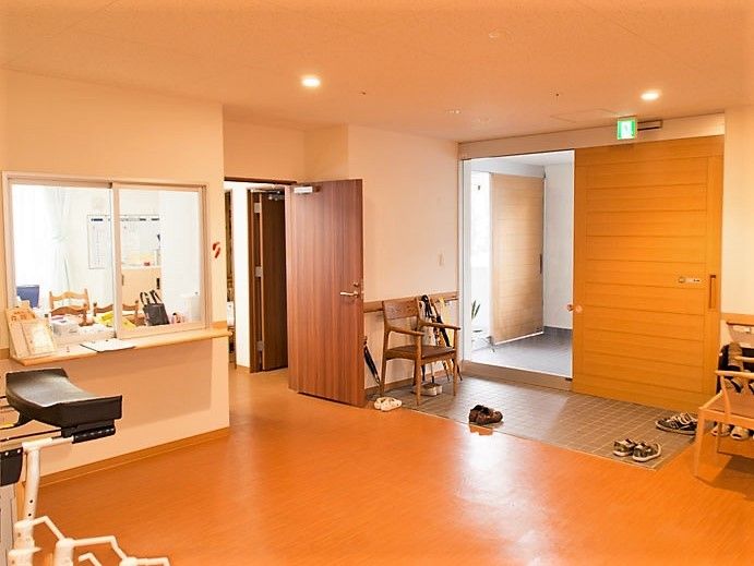 広く段差のないエントランス。落ち着いた色調の玄関が入居者様を出迎える。スタッフルームは入ってすぐにある。
