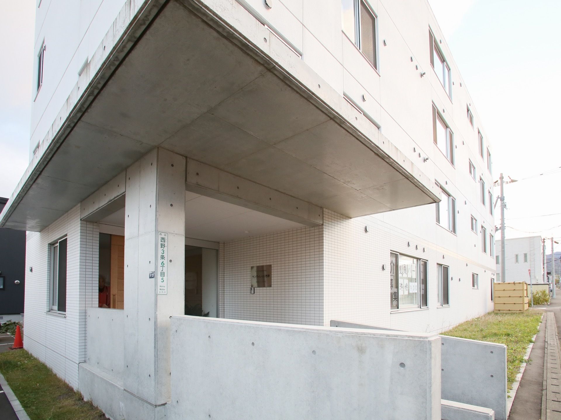 施設は鉄骨造り４階建ての建物である。建物横に駐車場が設けられている。エントランスには、大きなひさしが設置されている。