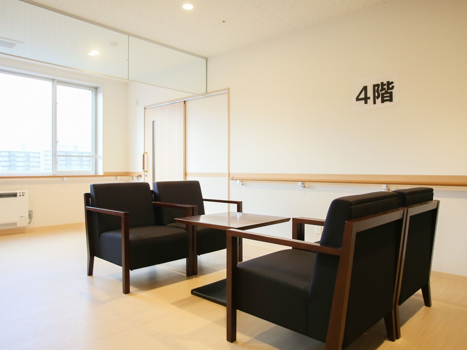 ４階のサンルームには、シックな応接セットが置かれている。壁に沿って手すりが取りつけられており、パネルヒーターが完備されている。