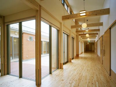木材の温もりが感じられ、大きな窓から日差しが入る廊下と吹き抜けの天井