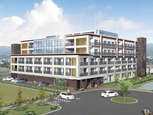 近代的な高層の施設である。２階以上から入居者様の居室などには窓とベランダが備わっている。施設各所へと明るい日の光が注がれている。