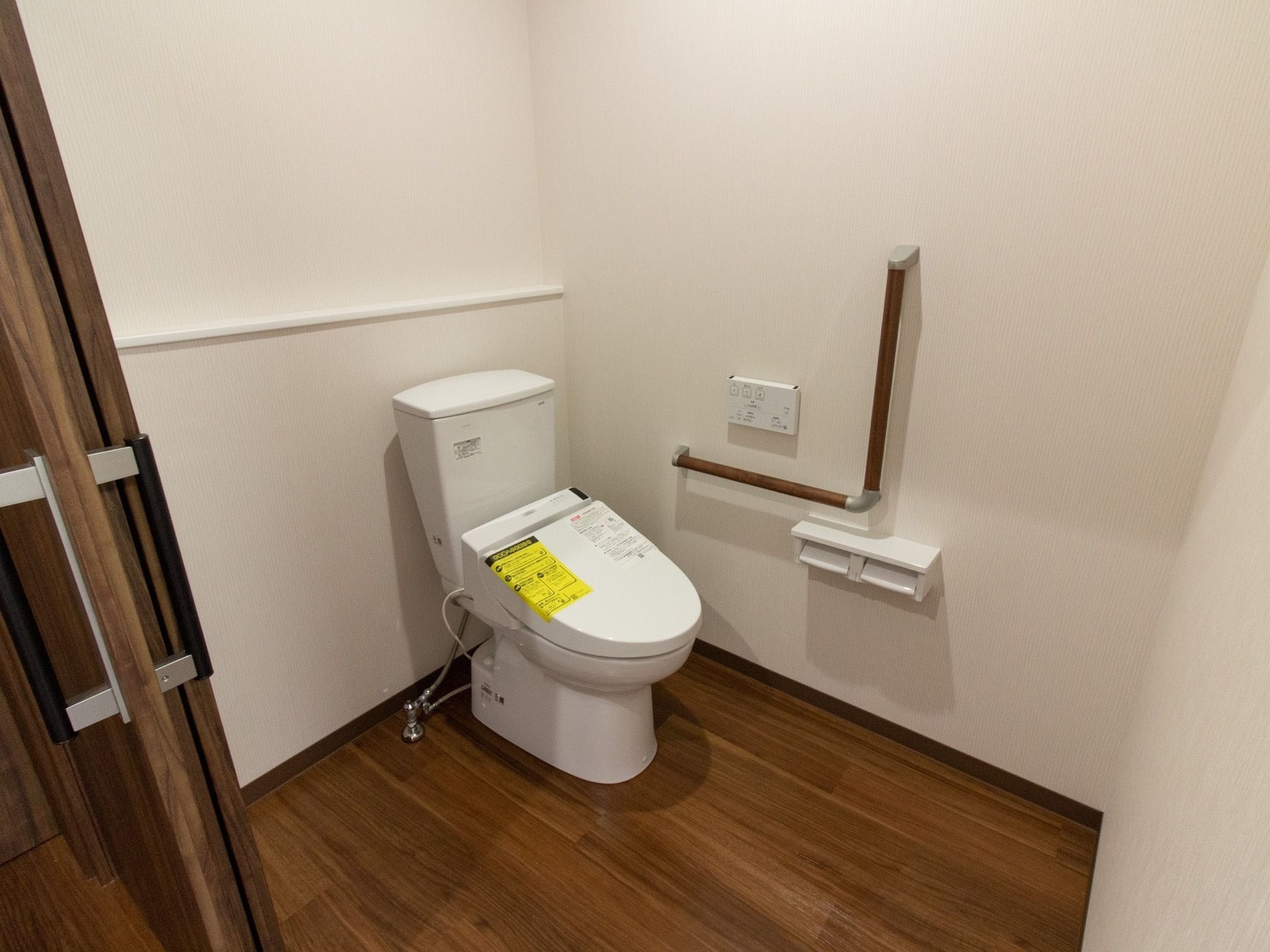 トイレは広いスペースがあり、壁にはＬ字型に手すりが設置されている。出入り口の扉はスライド式になっている。