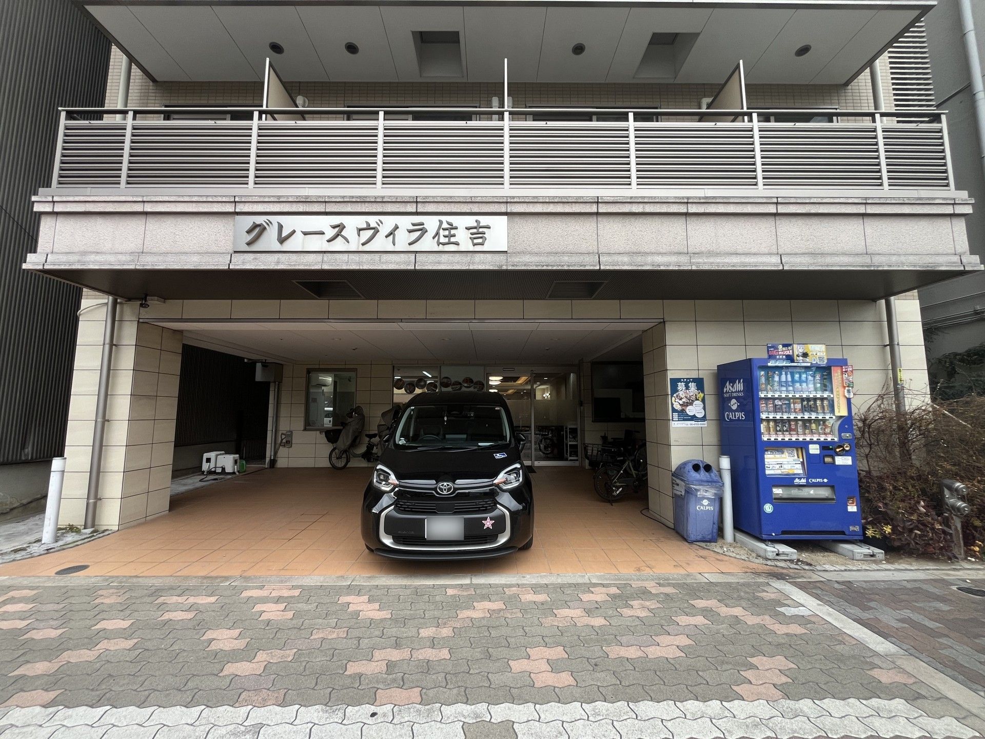 車椅子に座っている笑顔の高齢女性と後ろで支える女性ヘルパー