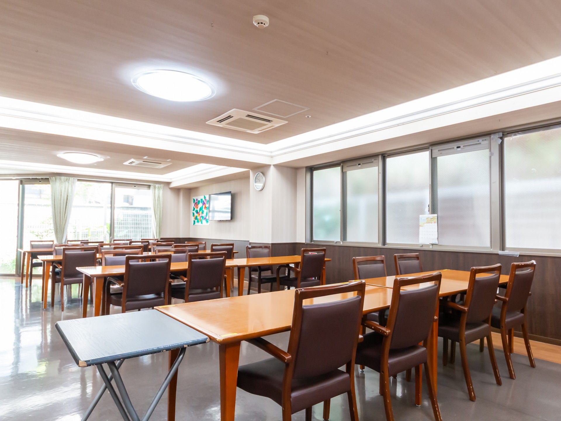 車椅子に乗って外出する高齢女性と介助をする男性ヘルパー