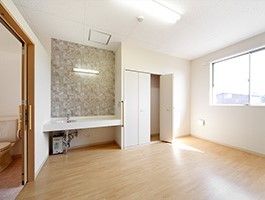 まだ家具が置かれていないシンプルな居室には車いす対応の洗面所や収納がある。