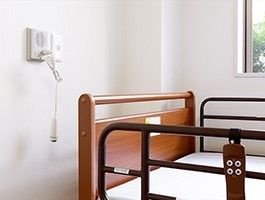 モーター式の介護用ベッドの脇にはスタッフにいつでもつながるナースコールがある。