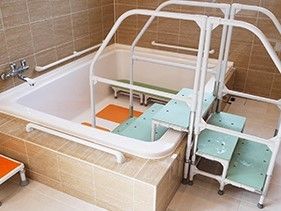 入居者様の入浴をサポートする介護入浴機器を導入している。手すりをもって階段を上り下りし、浴槽に入ることができる。