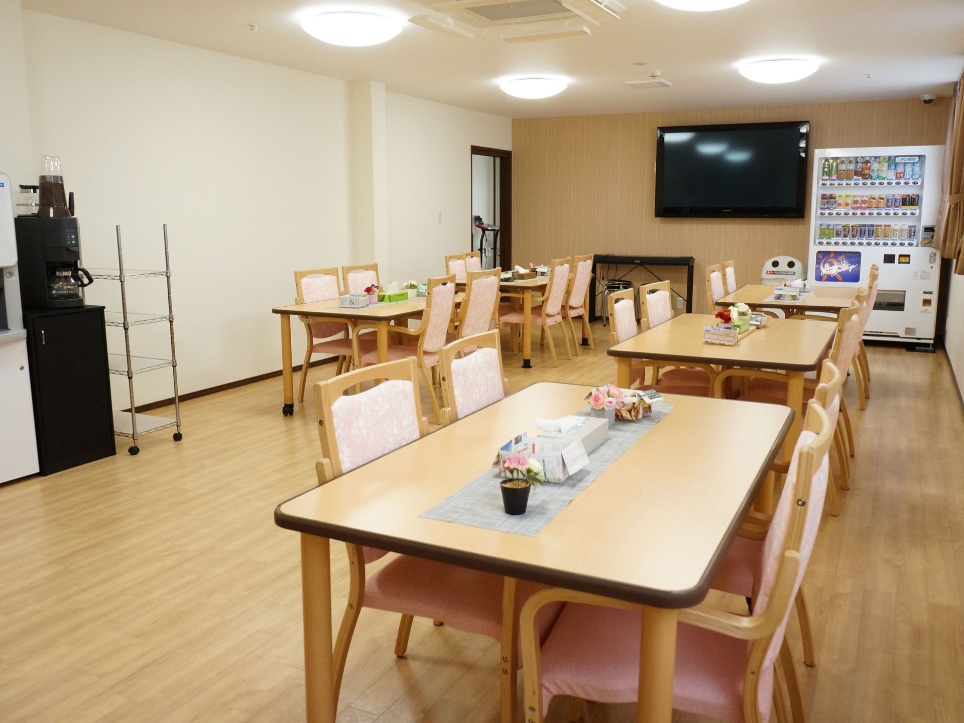 四人掛けのテーブルが中央に並べられており、壁にはテレビがかけられている。コーヒーメーカーや自動販売機も備え付けられている。