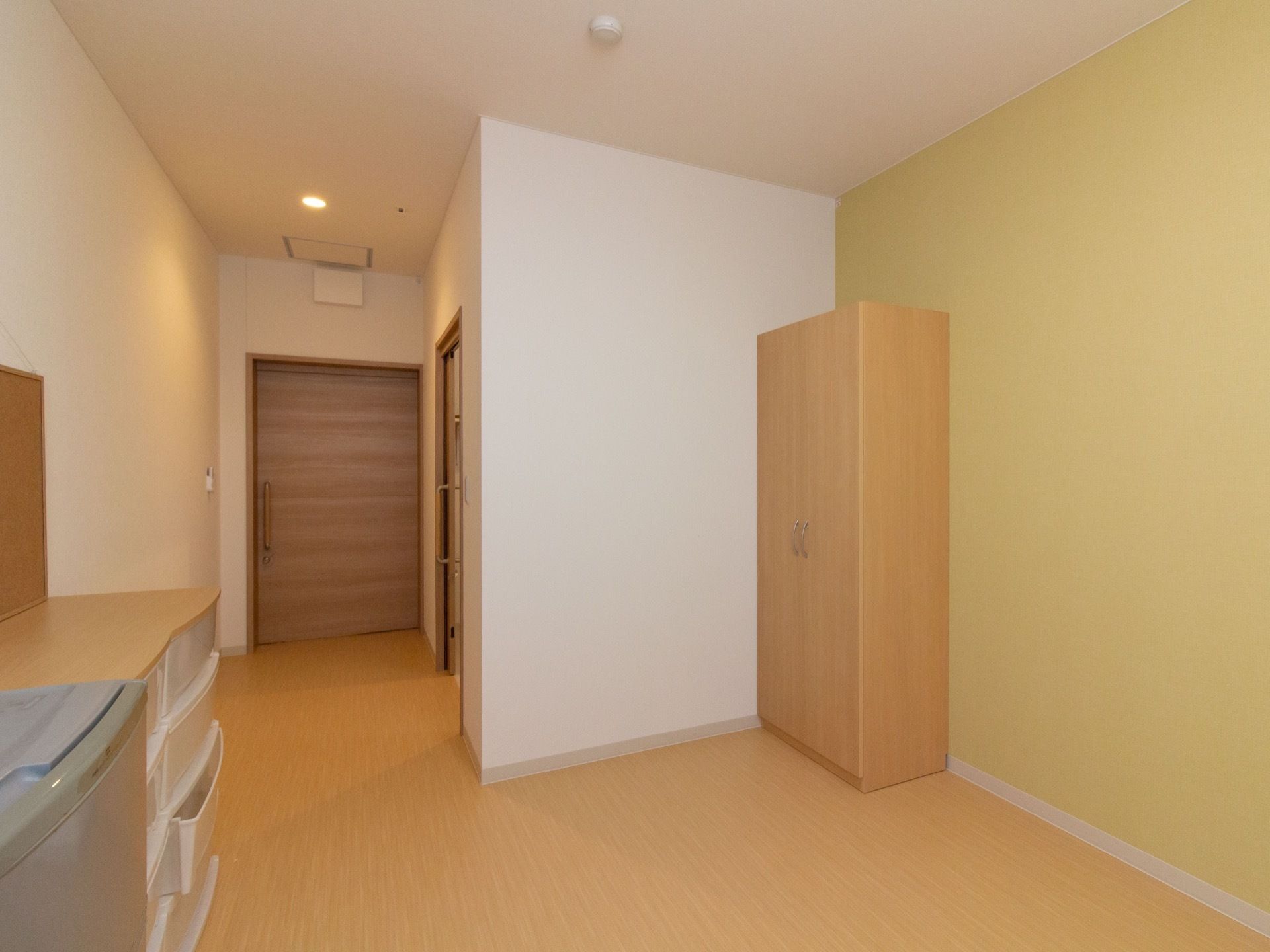 左奥に廊下へ続く扉あり、その手前にトイレへの入口がある。右側の壁際に、扉が観音開きのクローゼットが用意されている。