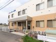 玄関前にひさしがついている。敷地境界には白い格子のフェンスが設置されている。玄関から道路までゆるやかなスロープになっている。