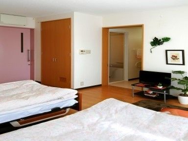 お二人でご入居できるようにベッドを２台設置している。また、観葉植物を置いて癒しの空間を演出している。