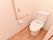 温水洗浄便座器が完備されているトイレには、持ち手が木製のL字型手すりや呼び出しブザーが設置されている。