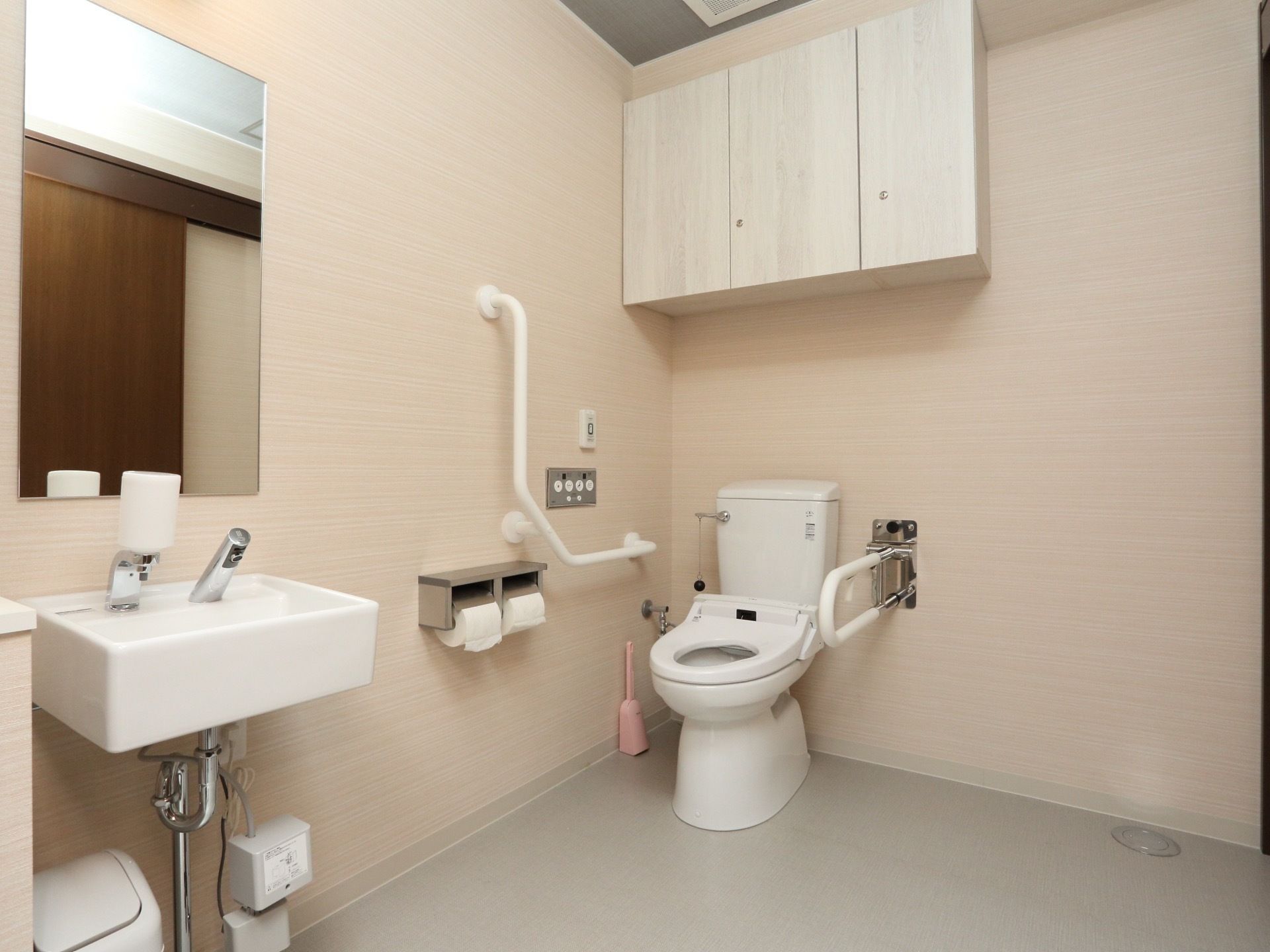 広々とした個室内に温水洗浄便座と洗面台が設置されている。トイレ介助しやすいように便座近くは広く空いている。