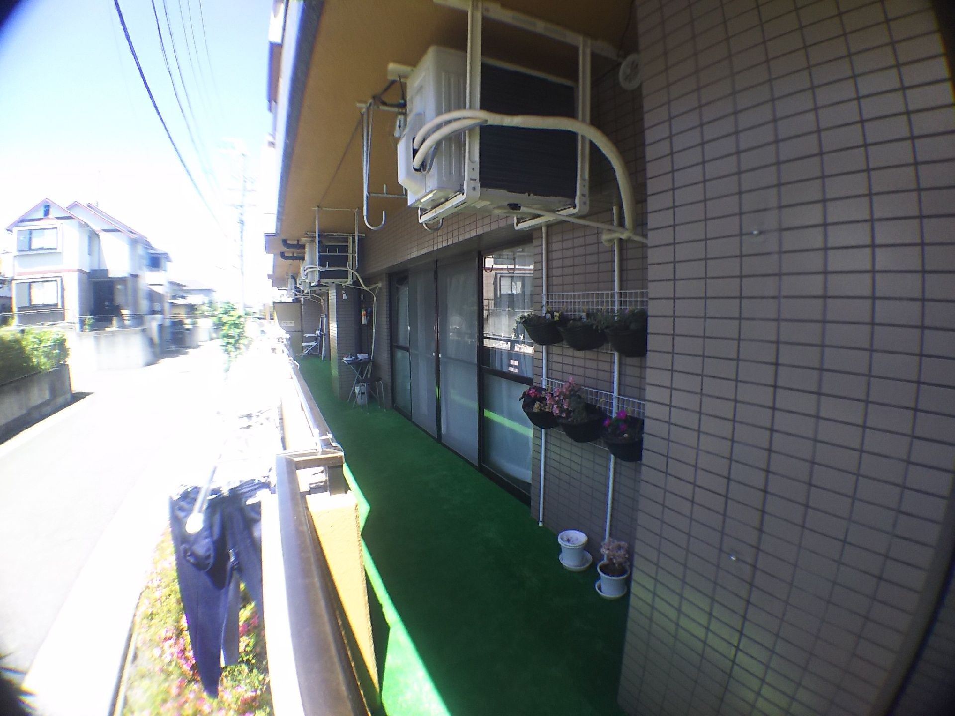 日当たりのよいベランダは幅が広く設計されていて、物干しのほかに趣味の園芸を楽しむこともできる。エアコンの室外機は上部に置かれている。
