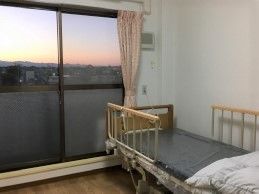 大きな窓があり、外の景色を楽しむことができる。介護用ベッドを設置しており、転落防止柵を取り付けているので安心である。