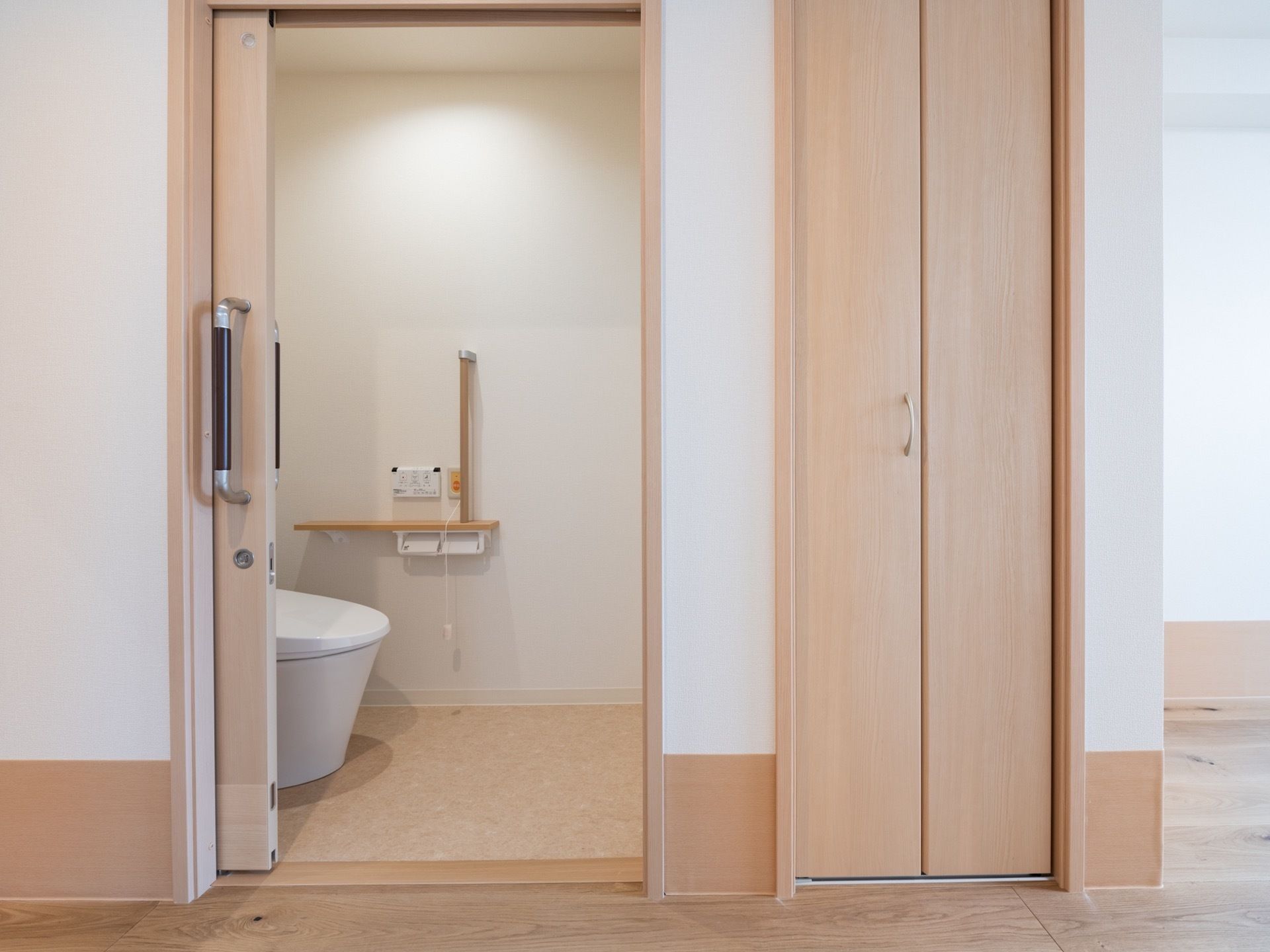 居室内にトイレがあり、清潔感のあるスペースである。手すりを設置しており、体を支えながら安全に利用することができる。