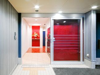 赤色を採用した鮮やかな配色となっているエントランス。バリアフリーで、車椅子をご利用の方も安心して出入りできる。