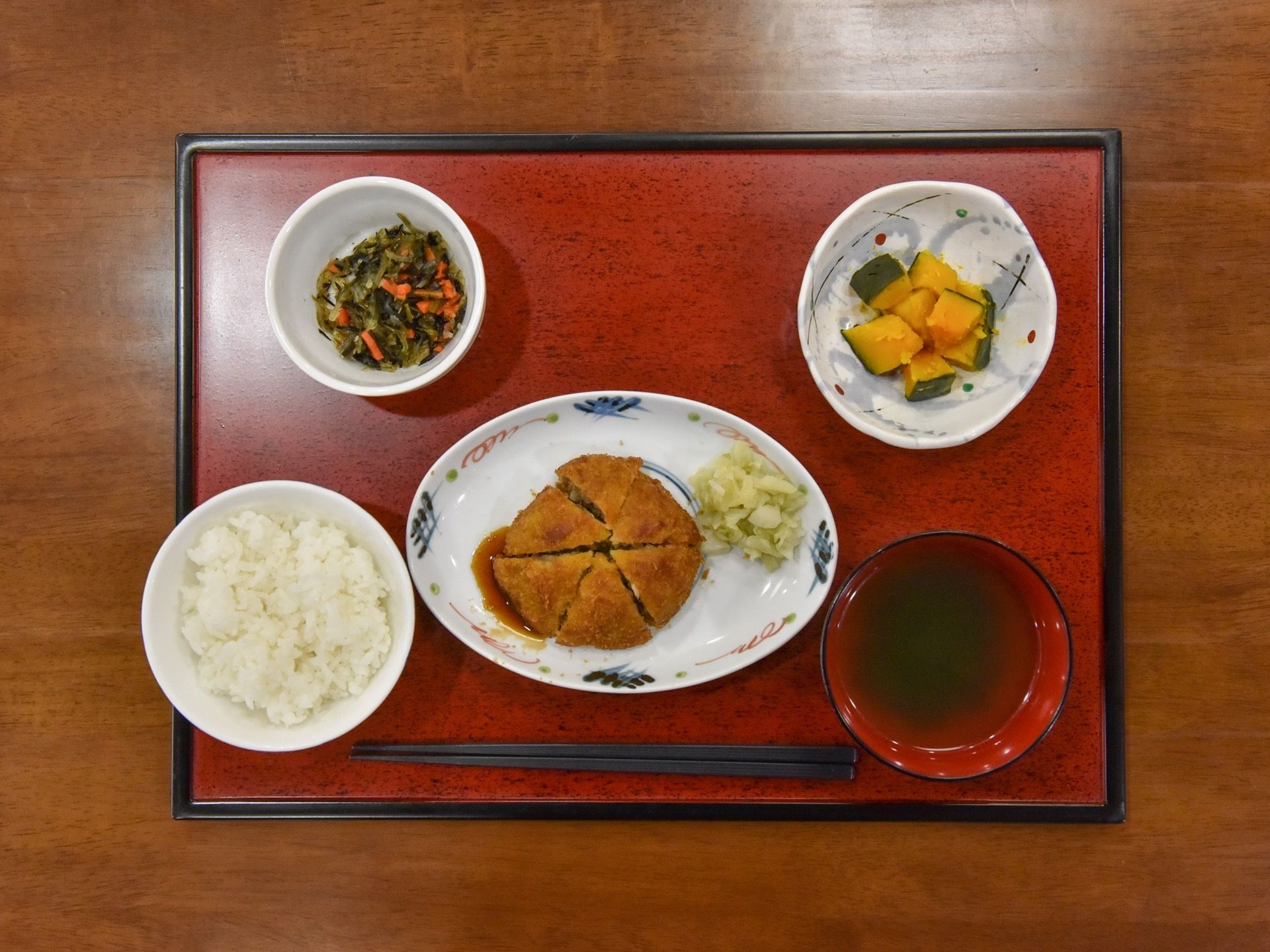 四角い和風のトレーの上に綺麗に盛り付けられた料理が乗せられている。メニューはご飯と味噌汁、ハンバーグ、煮物などの小鉢が２皿となっている。