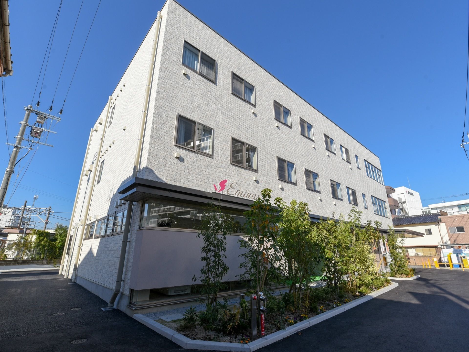 施設は、３階建ての建物で白い外壁になっている。建物の周りに木々が植えられているので、自然に触れながら過ごすことができる。