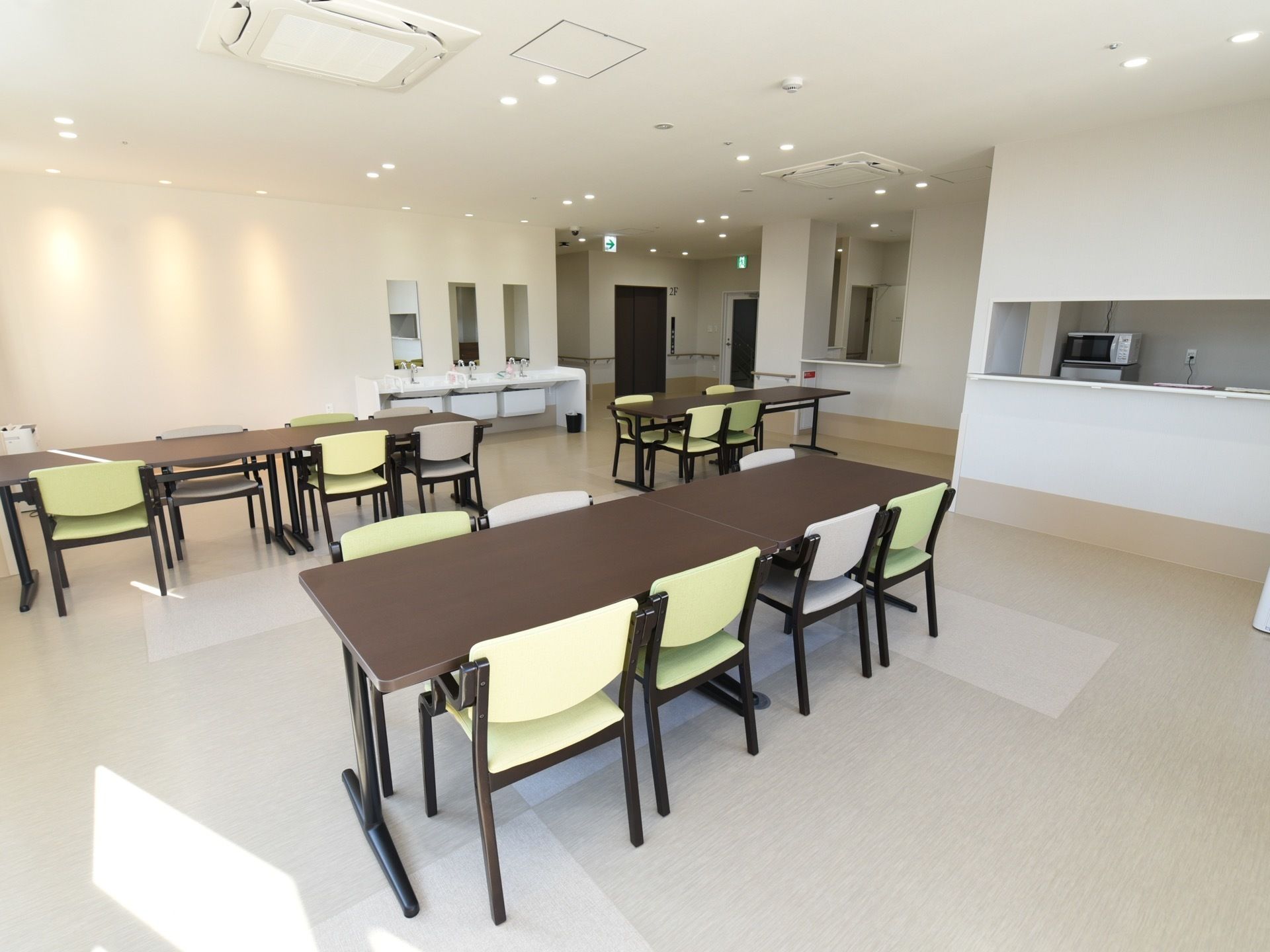 ゆとりあるスペースにテーブルとひじ掛け付きの椅子が設置されている。奥には洗面台があり、いつでも手を清潔にすることができる。