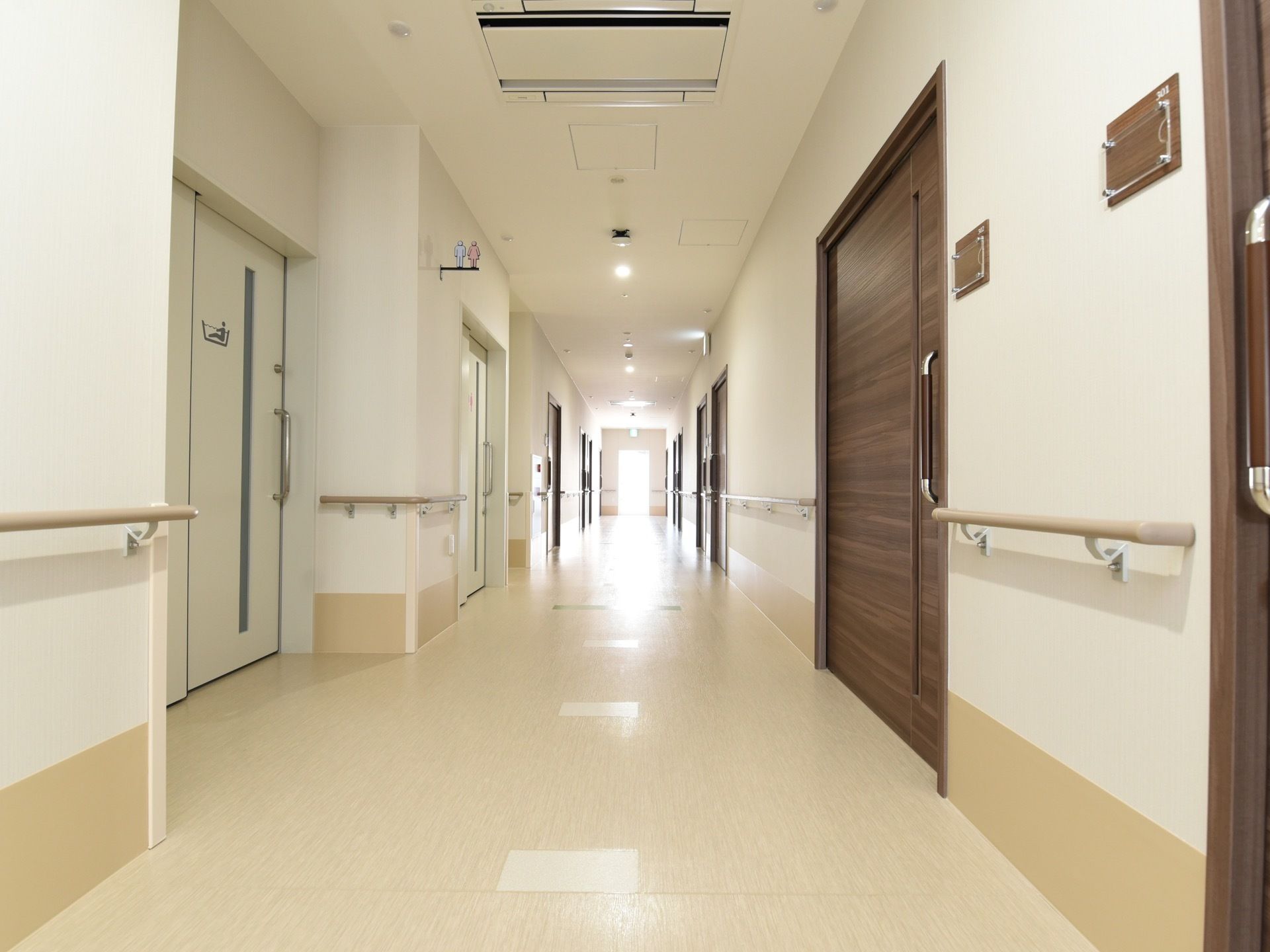 廊下には、ダークブラウンの居室の扉が並んでいる。スライド式になっており、大きな取っ手があるので安全に開閉することができる。